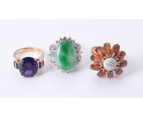 An amethyst ring, the central oval cut amethyst, claw set between square cut blue stones, stamped 14k 585, finger size K; tog