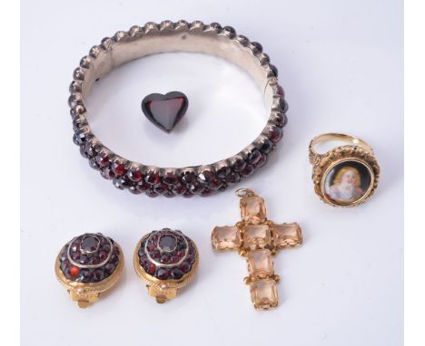 An enamel panel ring, the oval enamel within a foliate surround, finger size N; together with a garnet bangle, a pair of garn