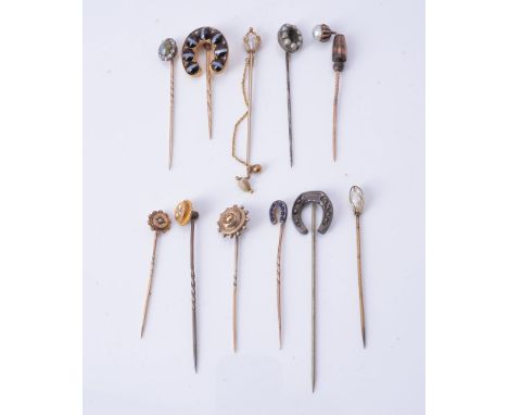 A group of stick pins, to include: a cat's eye chrysoberyl and diamond stick pin; together with ten further stick pins