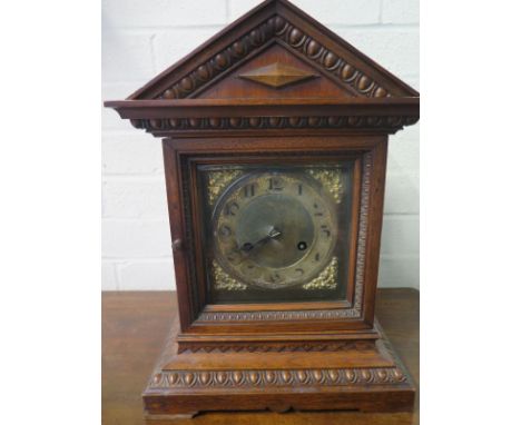 An 8 day striking mantle clock in a walnut case - Height 38cm 