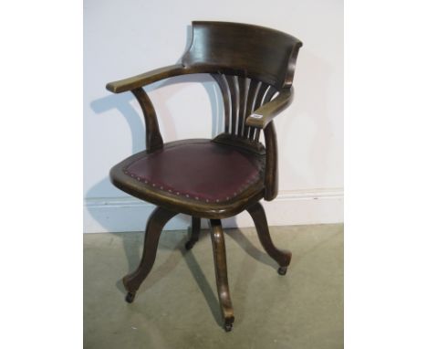 An early 1900's swivel office chair with a padded seat 