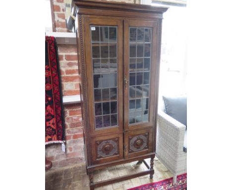 A 1930's oak glazed bookcase with leaded glazing bars and two cupboard doors - 184cm x 83cm 