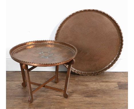 Large copper dish 20th Century, with pie crust rim, 71cm across approx overall, and a similar smaller example on a wooden fol