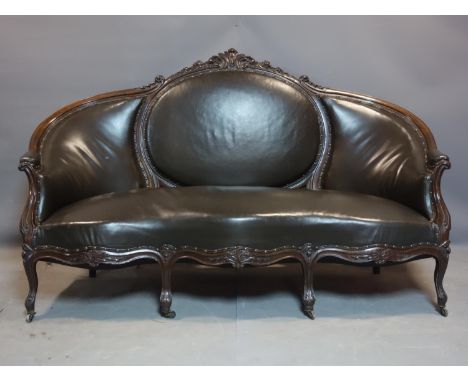 A late 19th/early 20th century French carved mahogany sofa, with studded leather upholstery, raised on cabriole legs and cast