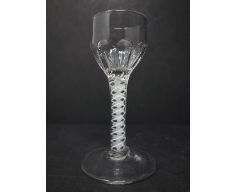 An early George III opaque-twist wine glass, c.1765, the ovoid bowl with panel moulding, the stem with conical foot, H.13.5cm