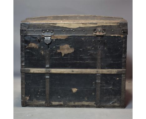 An early 20th century domed top trunk, H.62 W.71 D.45cm, hinges broken 