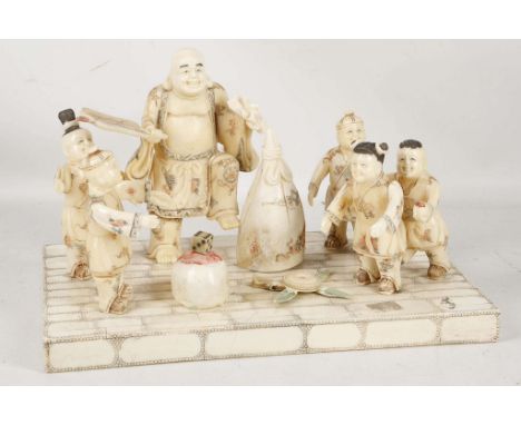 A Chinese carved tableau of children playing whilst a man with fan dances, man 16cm high, overall 30cm wide.