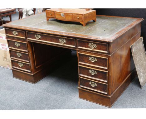 A mid 20th century, green leather topped, burr elm veneered twin pedestal desk, with an arrangement of drawers and side brush
