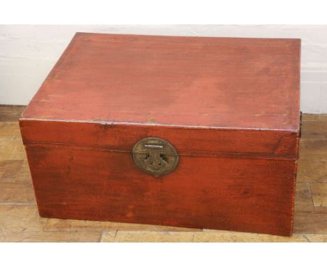 A Chinese red lacquer finish trunk, iron 'horn' handles, brass engraved lock, lined petal interior, 81cm wide.