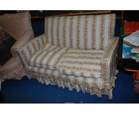 A two seater sofa with cream and brown ribbon style cover.