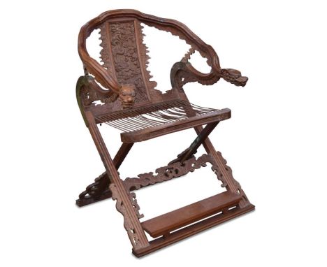 A 19th century Chinese hardwood folding chair, the back panel carved in relief with a dragon, the string seat above legs join