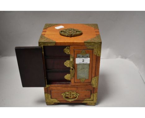 A modern miniature oriental jewellery chest having inlaid jade stone carved panels and brass fitments, 22cm tall.