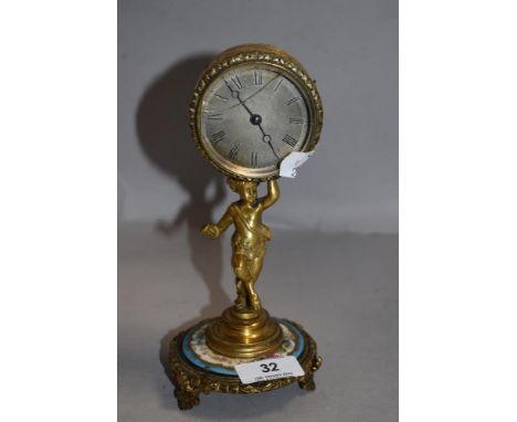 A French figural mantel clock having brass cast Pan figure holding brass cased clock on porcelain plinth AF
face measures 5cm