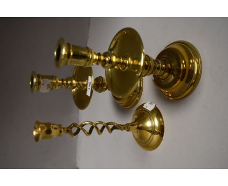 A pair of good quality brass candlesticks, each with central drip tray, sold with a single brass twist candlestick