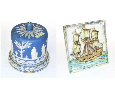 A Karlsruhe ceramic tile, square and with a ship in relief, 32cm square, Together With: a Jasper ware style cheese dish and c