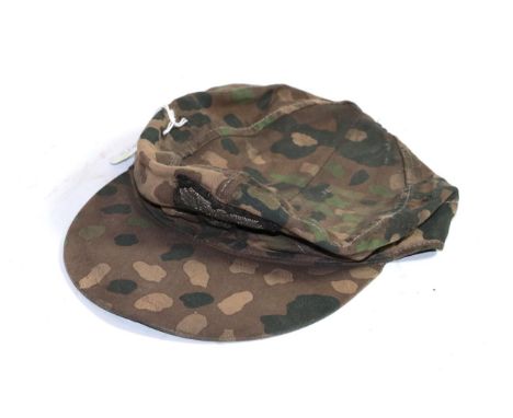 A copy of a German Third Reich SS camouflage field cap, of herringbone twill, the exterior with 'pea pattern' camouflage, wit