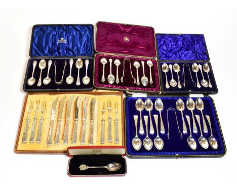 A collection of cased sets of spoons, including three sets of six teaspoons and sugar tongs, a spoon with the coat of arms of