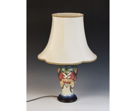 A Moorcroft lamp decorated in the "Anna Lily" pattern designed by Nicola Slaney, of inverted baluster form set to a turned wo