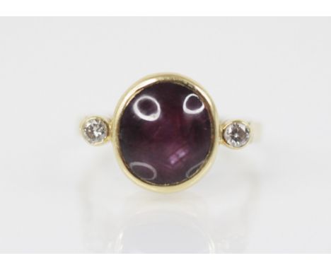 A star ruby and diamond ring, the central (untested) ruby measuring 10.32mm x 9.24mm x 6.48mm, with a brilliant cut diamond t