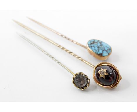 A Victorian garnet and diamond set stick pin, the central garnet carbuncle surmounted by a rose cut diamond within a starburs