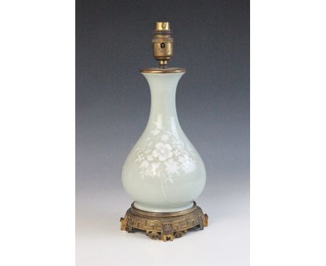 A Chinese porcelain celadon vase, 19th century, of pear shape (Yuhuchunping), decorated with white overlay foliate sprays, co