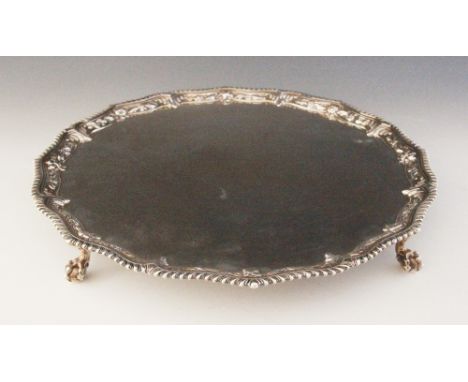 A George III silver salver, Richard Rugg I, London 1768, the circular salver with gadrooned and cast floral rim, raised on fo