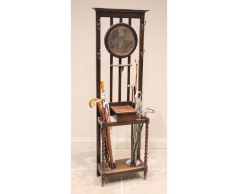 An early 20th century oak Arts & Crafts hall stand in the manner of Mackintosh, the rail back centred with a circular mirror 