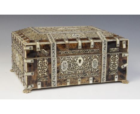 A 19th century Indian tortoiseshell and ivory sewing box, of sarcophagus form raised on four lion paw feet, with ivory straps