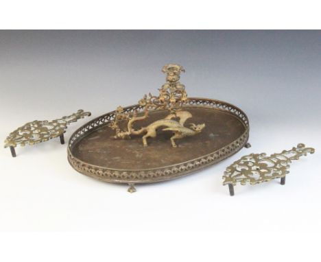 A Victorian novelty brass candlestick, modelled as a dragon with wings raised, scrolling tail terminating in a foliate sconce