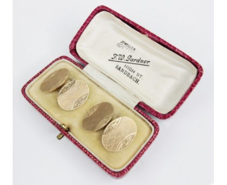 A pair of George V 9ct gold cufflinks, each oval panel with engine turned detail and engraved floral hemisphere segments, eac
