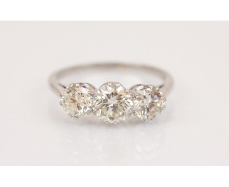 A diamond three-stone ring, the central round brilliant cut diamond weighing approximately 0.85 carats, with a round brillian