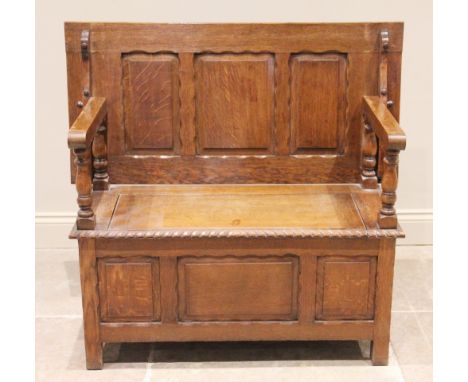An early 20th century medium oak monks bench, the three panel sliding back rest raised upon four baluster turned supports and