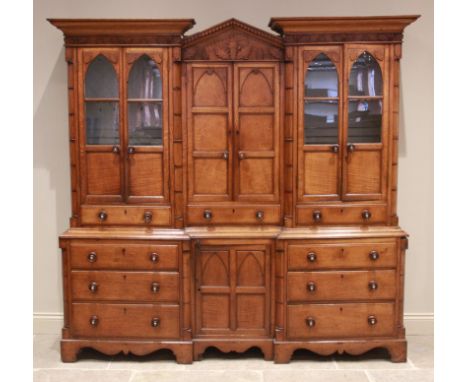 A mid 19th century inverted breakfront oak housekeepers cupboard, the central architectural pediment flanked by a moulded cor