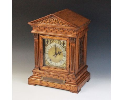 A late 19th century oak cased German bracket clock, by Winterhalder and Hofmeier, the architectural case applied with simulat