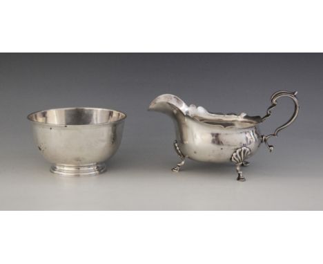 A George V silver sauce boat by E S Barnsley & Co, Birmingham 1918, of bellied form with shaped border on three shell-capped 