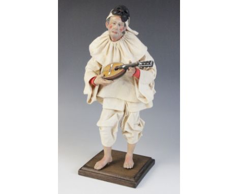 An Italian terracotta and painted figure of Pulcinella, 20th century, the figure modelled standing upon a plinth, with mask a