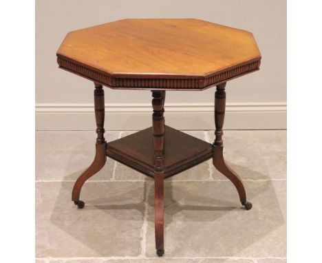 An Edwardian walnut octagonal library table, the top with a lobed frieze raised upon four turned uprights extending to out sw