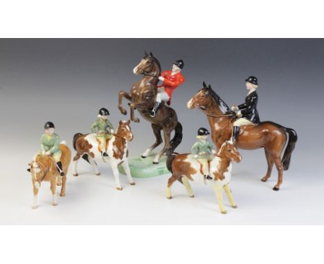 A Beswick huntswoman on brown horse, model No. 1730 (style two), discontinued 1975, 21.5cm high, with a Beswick huntsman on r