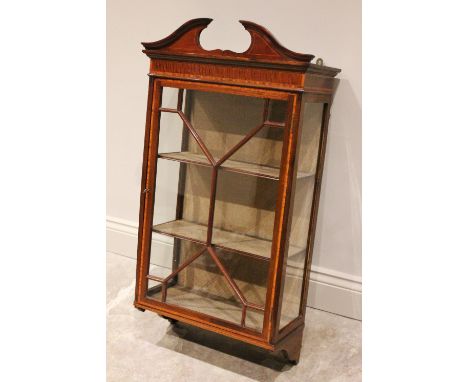 An Edwardian Sheraton revival wall hanging mahogany display cabinet, the broken architectural pediment above a single astraga