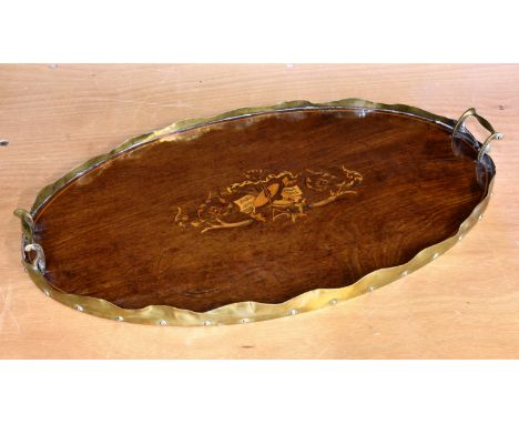 An Edwardian plum pudding mahogany and marquetry oval tray, with marquetry musical trophy, scalloped brass gallery and brass 