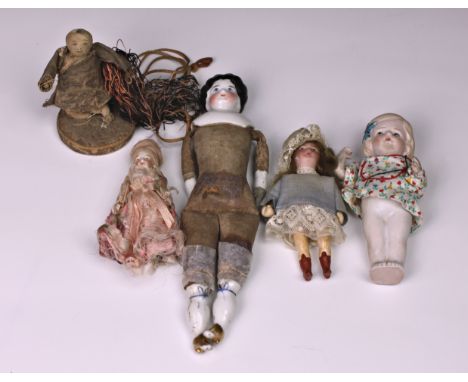 A collection of German bisque doll's house dolls, the first elaborately dressed in a pink satin dress, 3½in. (8.8cm.) tall, t