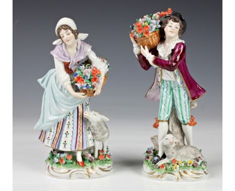 A pair of Sitzendorf porcelain figures, 20th century, depicting a gent and maiden with flower baskets and lambs at their feet