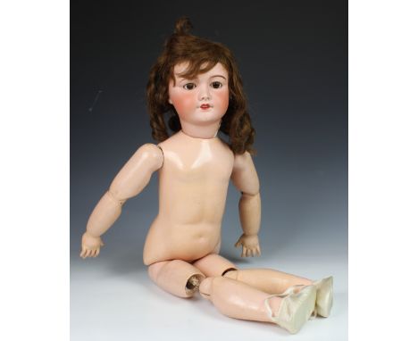 A large German bisque head doll, stamped '12', with weighted dark brown eyes, real hair lashes and hair, painted raised brows