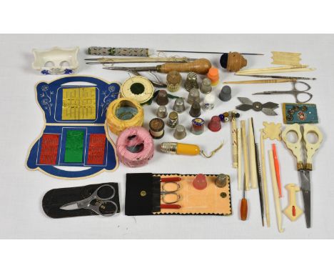 A collection of vintage and antique sewing accessories, comprising of three silver thimbles; various other thimbles to includ