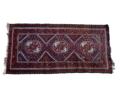 An Ersari rug, worked in pale aubergine, dark red, orange, dark brown and ivory, with three toothed octagonal medallions with