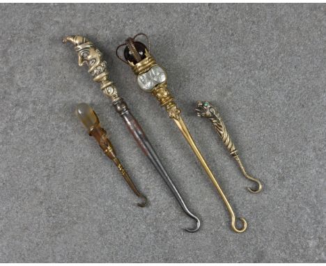 A small group of four novelty Victorian and later button hooks, comprising of a Mr Punch version, 4¾in. (12cm.) long; gilt me