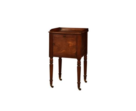 A late Regency mahogany bedside pot cupboard, the three-quarter tray top over a single cupboard door, raised on turned and re