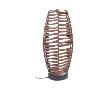 An early 2000 vintage rattan woven lamp light having an open woven shade with interior white cylindrical shade. Raised on a b