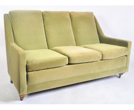 A vintage 20th century green upholstered three seater sofa. The sofa having a tapering back rest over straight elbow rests. R