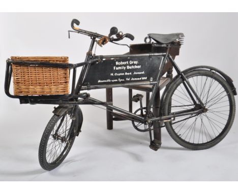 A vintage 20th century trade / butchers advertising bicycle having a large wicker basket to the front with tubular metal fram